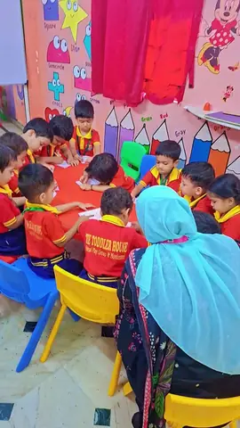 Teacher guiding children while they colour
