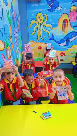 Children showing colouring cards in our ocean-mural classroom